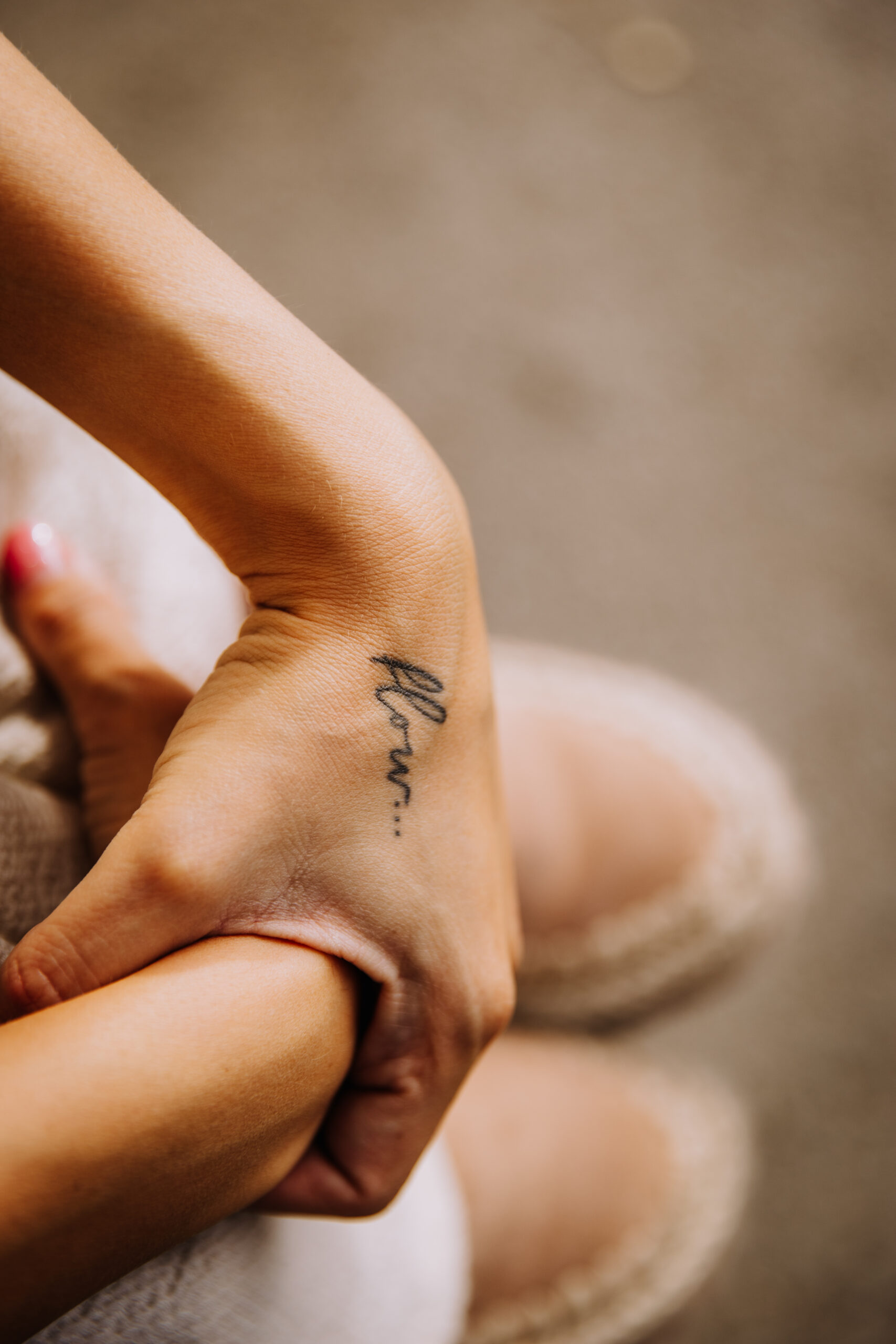 Ukrštene šake žene sa tetovažom